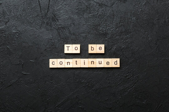 To be continued word written on wood block. To be continued text on cement table for your desing, concept