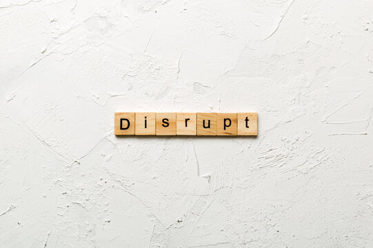 DISRUPT word written on wood block. DISRUPT text on cement table for your desing, concept