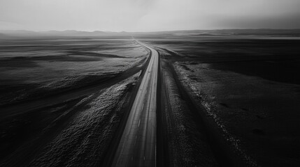 A desolate, straight highway cuts through the flat landscape, disappearing into the distance.