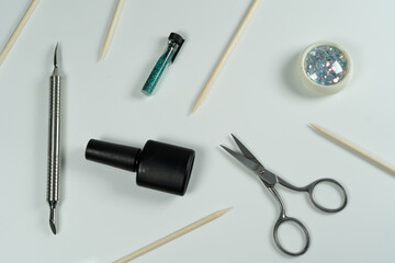 A flat-lay composition for a manicure professional, featuring tools like scissors, gel polish, and cuticle sticks.