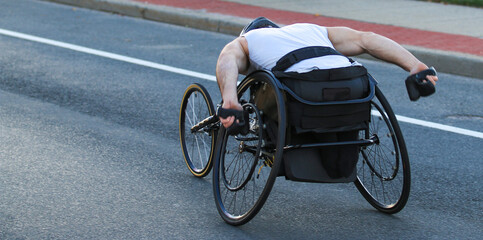 Athlete Racing With Determination Along Urban Street in Wheelchair