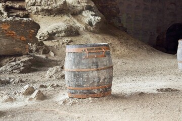Summer vacation and travel. An empty old wooden barrel stands in a deserted grotto