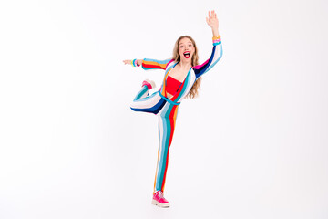 Vibrant young woman in striped overall striking a playful pose with enthusiasm, set against a clean...