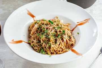 Asian noodles in a plate with sauce and vegetables. photos for the menu