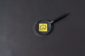 Magnifying glass with a sad emoji