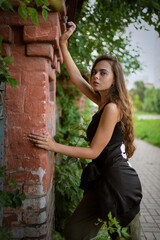 Beautiful young woman posing outdoors near an old brick building..