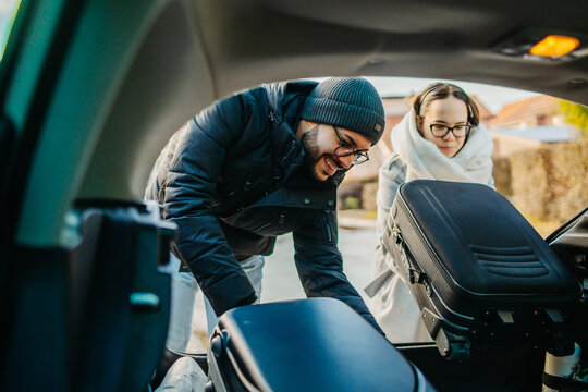 Boyfriend and girlfriend packing suitcases in car preparing to travel	
 - Powered by Adobe