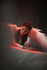 Beautiful angel woman in white clothing with large white wings posing on a white background...