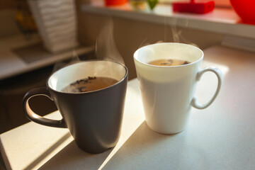 Two cups of warm tea standing on the counter