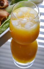 Glass of orange juice with ice cubes