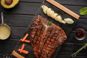 Grilled porterhouse beef meat Steak on grill with Mashed potatoes, carrots and sauce. dark...