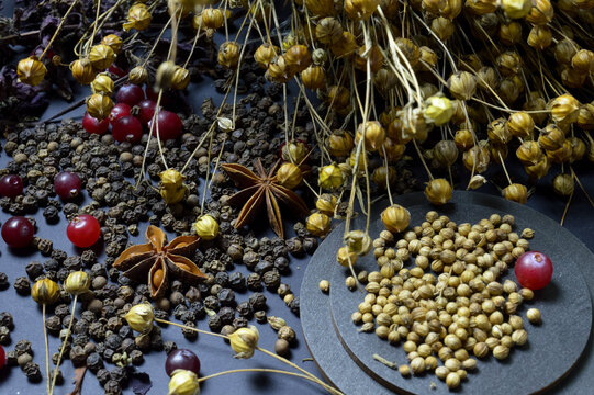 various spices scattered on a dark background with bunches of grass, laurel leaves, berries and other spices for cooking fragrant Eastern and Midwestern food. High quality photo