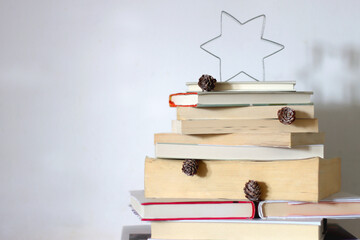 Christmas tree made with stack of books. Cute Christmas tree for booklovers. Selective focus.