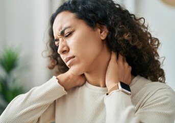 Young woman massaging her neck, suffering from chronic pain after long working day