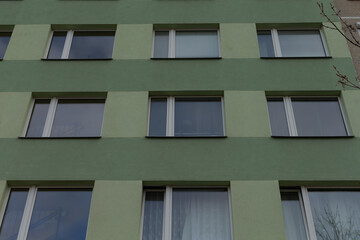 A green building featuring an abundance of windows all over its exterior, providing ample natural light and a welcoming atmosphere
