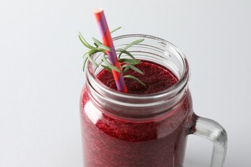 Fresh beetroot smoothie in mason jar on light background, closeup