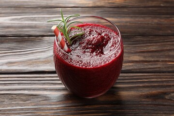Fresh beetroot smoothie with rosemary in glass on wooden table, closeup