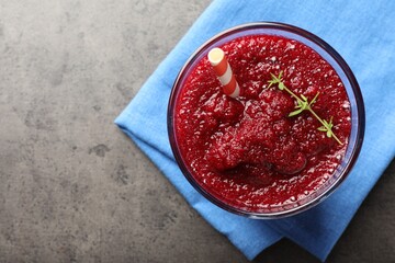 Fresh beetroot smoothie with thyme in glass on grey textured table, top view. Space for text
