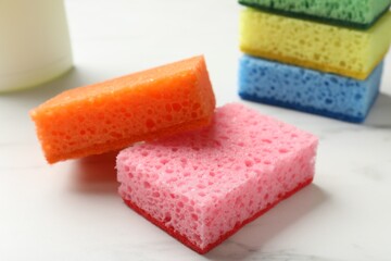 Many soft sponges on white table, closeup