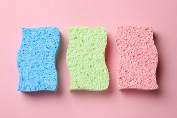 Soft sponges on pink background, top view