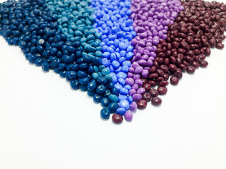 Various colors of masterbatch granules arranged on a white background, polymer carrier of color pigments in the plastic industry. Suitable for plastic company catalog design