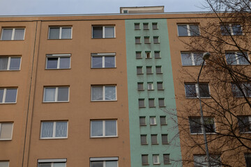 A tall building with a prominent green stripe running down its side features an abundance of windows, contributing to its modern design