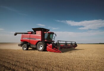 Obraz premium A bright yellow combine harvester is actively working in a vast field
