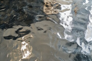 Abstract metallic texture with gray and silver wavy reflections.