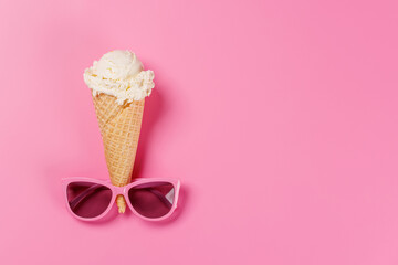 A playful ice cream cone wearing stylish sunglasses, set against a vibrant pink background