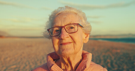 Happy, beach and portrait of elderly woman with smile for summer, travel and weekend in Australia. Morning, sunrise and face of senior person by sea for adventure, journey and relax in retirement