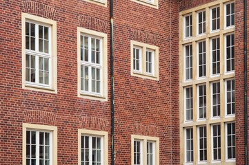 Red brick wall with white windows showing urban architecture