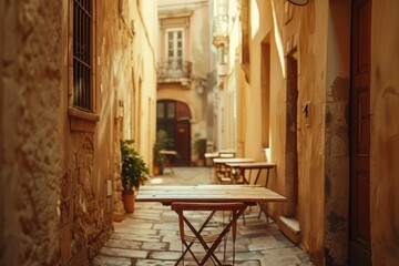 A narrow alleyway with tables and chairs set up, ready for use