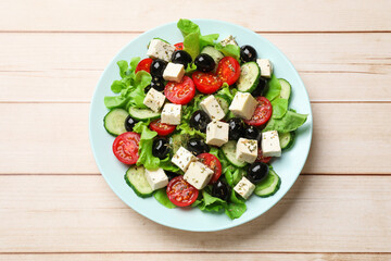 Delicious salad with feta cheese on white wooden table, top view