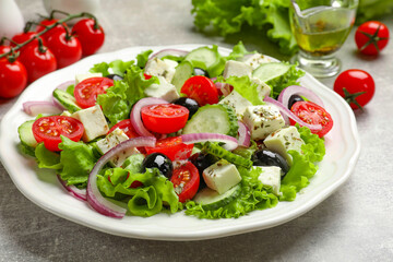 Delicious salad with feta cheese on gray textured table, closeup