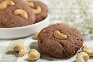 Tasty chocolate cookies with cashew on table, closeup