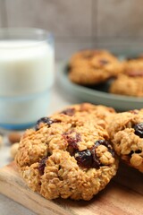 Delicious oatmeal cookies with raisins and nuts on table, closeup