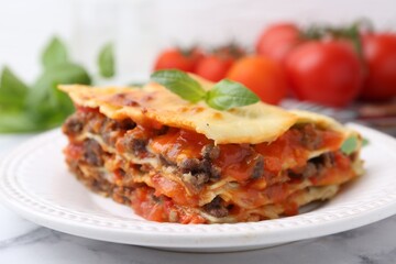 Delicious cooked lasagna on white marble table, closeup