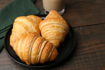Tasty fresh croissants on wooden table, closeup. Space for text