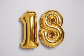 Coming of age party - 18th birthday. Number shaped balloons on light grey background