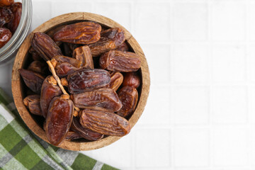 Tasty dried dates on white tiled table, top view. Space for text