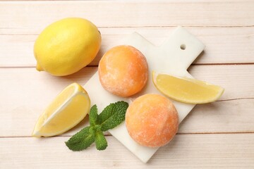 Delicious mochi, lemons and mint on wooden table, flat lay