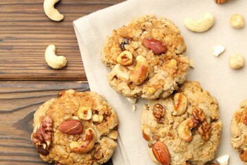 Tasty cookies with nuts on wooden table, top view