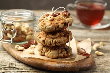 Tasty cookies with nuts on wooden table, closeup