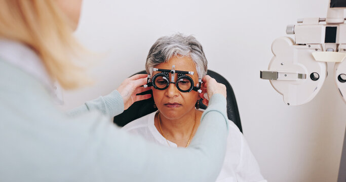 Doctor, optometry and woman with trial lens for eye care, consultation or hands in clinic for health exam. Ophthalmologist, test and senior patient with frame for vision check, wellness or correction