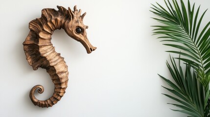 Fototapeta premium Wooden seahorse sculpture with palm leaf on white background.