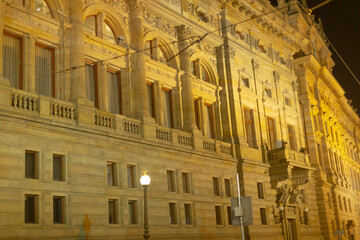 Obraz premium A large and impressive building with numerous windows is beautifully illuminated during the night, creating a captivating sight for onlookers