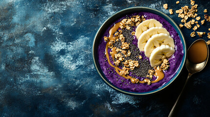 A vibrant acai bowl topped with granola, banana slices, chia seeds, and a drizzle of peanut butter.