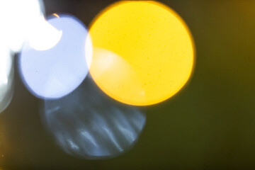 A blurry and indistinct picture of a street light shining at night, casting its warm glow in shades of yellow and orange