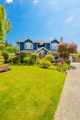 Two story stucco luxury house with nice summer  landscape in Vancouver, Canada, North America. Day time on June 2024.