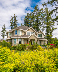 Two story stucco luxury house with nice summer  landscape in Vancouver, Canada, North America. Day time on June 2024.